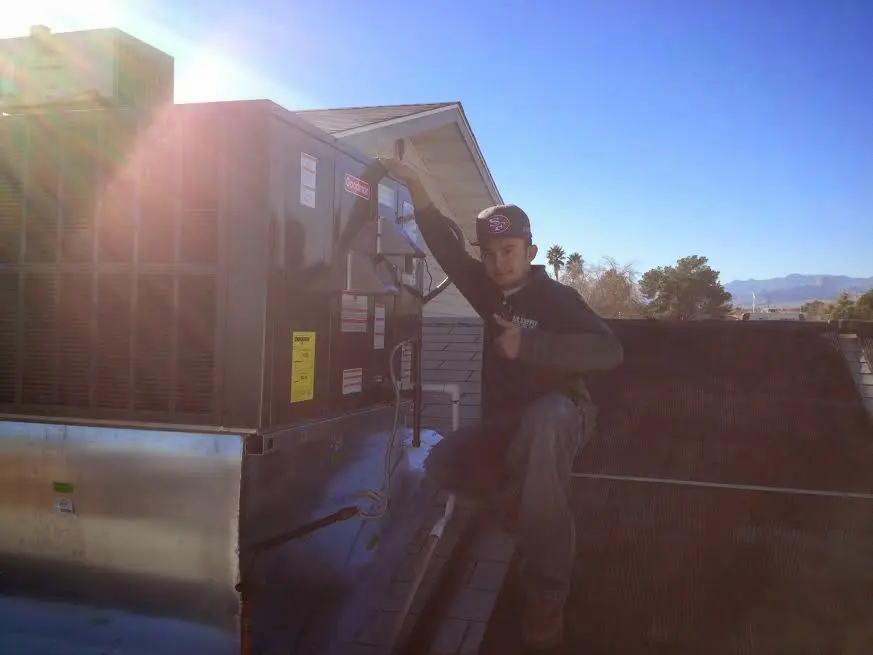HVAC technician performing Air Duct Cleaning on a rooftop unit in Fairview
